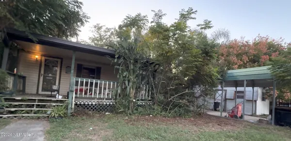 a view of a house with a yard and wooden fence