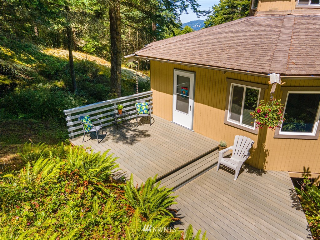 3625 Green Cliffs Road Anacortes, WA 98221 - Photo 8 of 26 a view of a roof deck with table and chairs a barbeque with wooden floor and fence