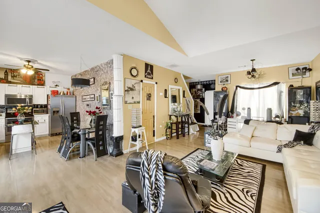 a living room with lots of furniture and view of kitchen