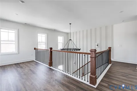 a view of a hallway with wooden floor and windows