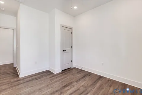 an empty room with wooden floor and entrance