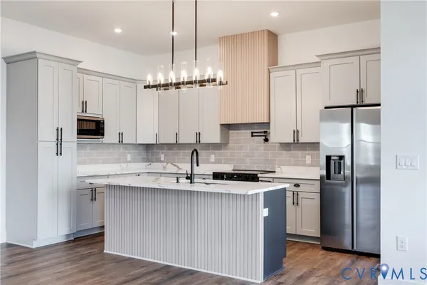 a large kitchen with kitchen island a sink stainless steel appliances and cabinets