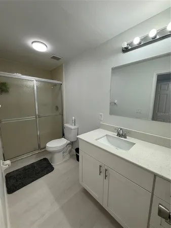 a bathroom with a granite countertop sink a toilet and a mirror