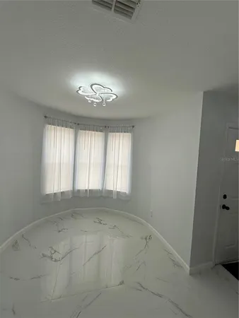 an empty room with a empty space and windows