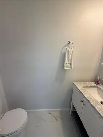 a bathroom with a granite countertop toilet and a sink