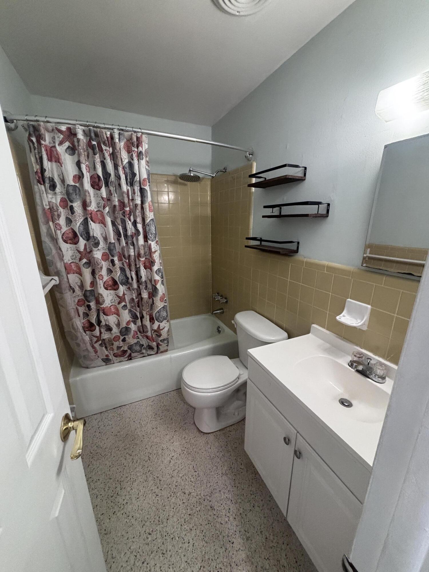 202 Balboa Street, Unit A Fort Pierce, FL 34949 - Photo 7 of 10 a bathroom with a sink a toilet and shower