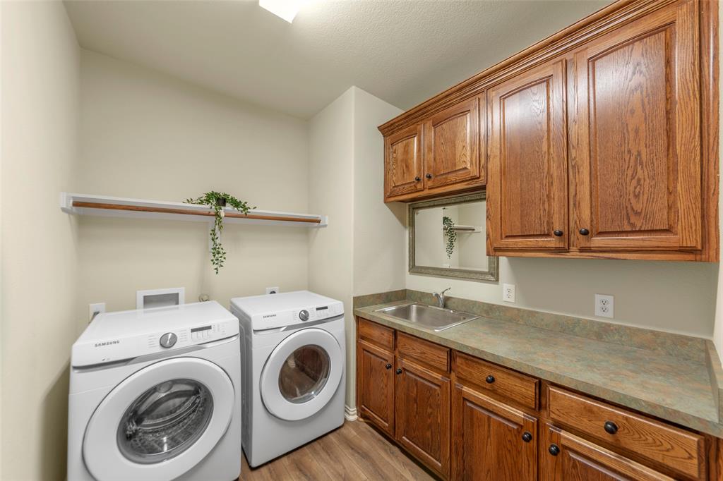 5143 Stream Crest Way Fairview, TX 75069 - Photo 21 of 35 Laundry area with light wood finished floors, cabinet space, and independent washer and dryer