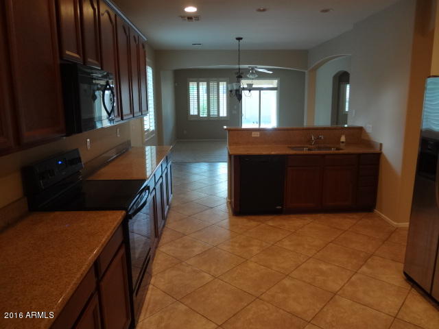 6837 West Carson Road Laveen, AZ 85339 - Photo 5 of 21 a kitchen with stainless steel appliances granite countertop a refrigerator and a stove top oven