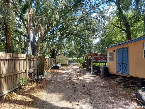 a view of a house with backyard space and wooden fence
