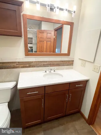 a bathroom with a sink a toilet and a mirror