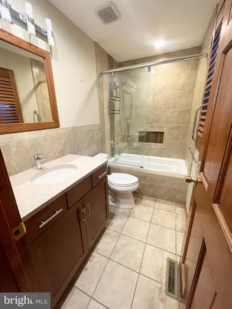 a bathroom with a sink a toilet a mirror and shower