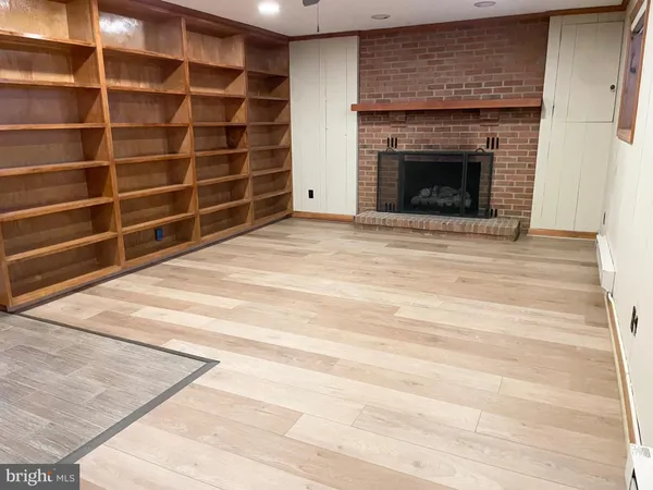a view of an empty room with a fireplace and a window