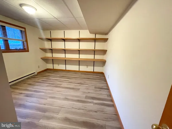 a room with a wooden floor and windows