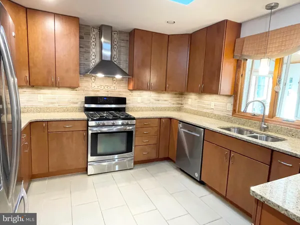 a kitchen with granite countertop a stove sink and cabinets