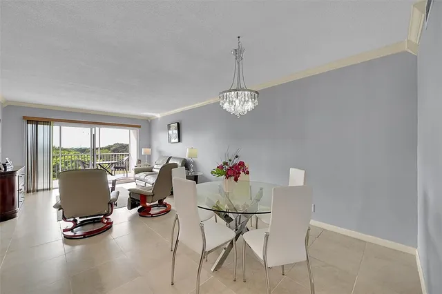 a living room with furniture a flat screen tv and a floor to ceiling window