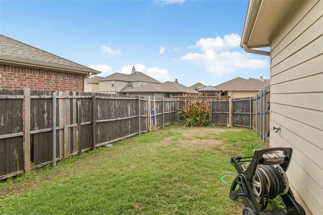 a view of a backyard with a wooden fence