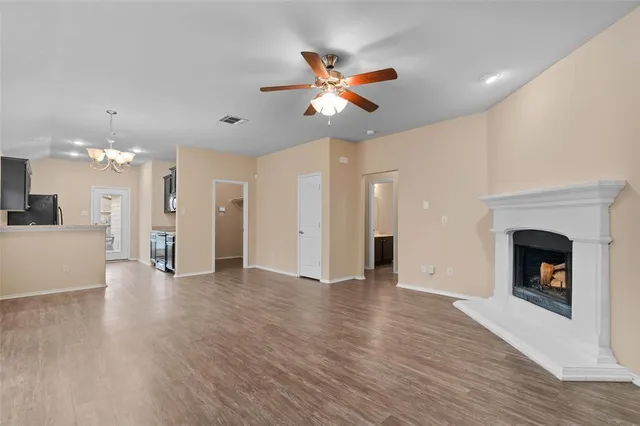 a view of an empty room with a fireplace and window