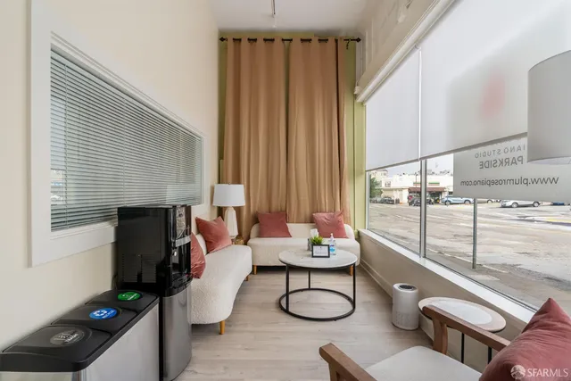 a view of a workspace with furniture and a window