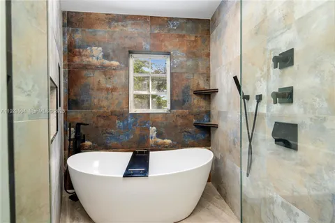 a white bath tub sitting in a bathroom next to a window