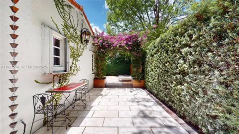 a path view of a house with a flower garden