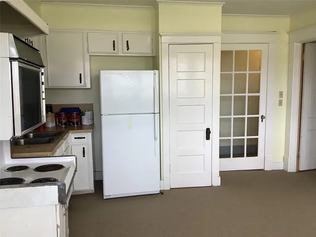 a kitchen with stainless steel appliances a dining table chairs and refrigerator