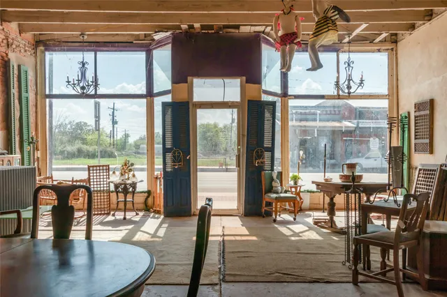 a dining room with wooden floor a glass table and chairs