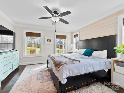 a bedroom with a bed a chandelier and dresser
