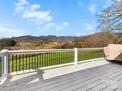 a view of a balcony with wooden floor & fence