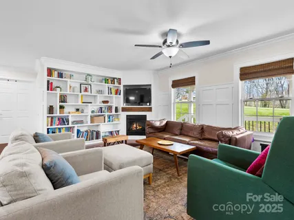 a living room with furniture ceiling fan and a window
