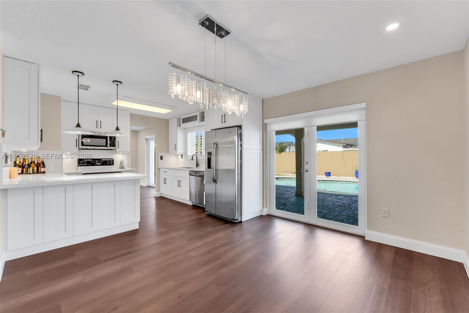 9567 Southwest 59th Terrace Miami, FL 33173 - Photo 11 of 36 a large white kitchen with cabinets and wooden floor