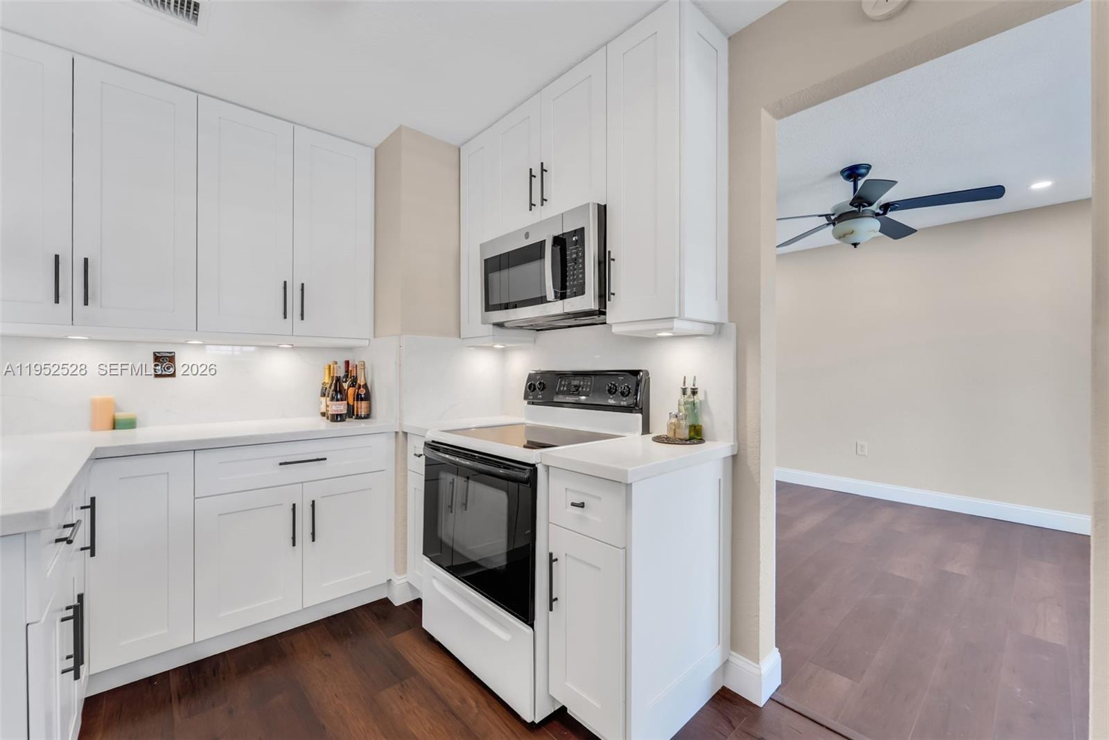 9567 Southwest 59th Terrace Miami, FL 33173 - Photo 13 of 36 a kitchen with stainless steel appliances white cabinets and a sink