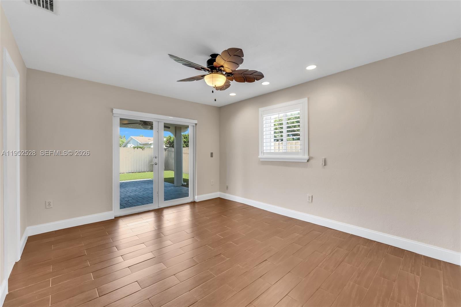 9567 Southwest 59th Terrace Miami, FL 33173 - Photo 22 of 36 a view of an empty room with window and wooden floor
