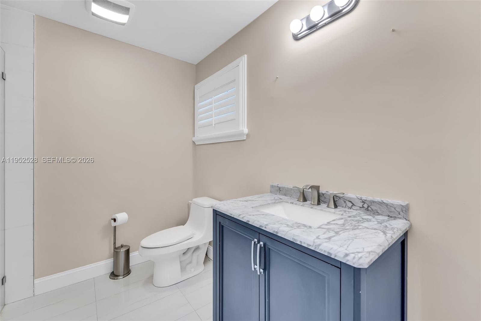9567 Southwest 59th Terrace Miami, FL 33173 - Photo 25 of 36 a bathroom with a granite countertop sink a toilet and a mirror