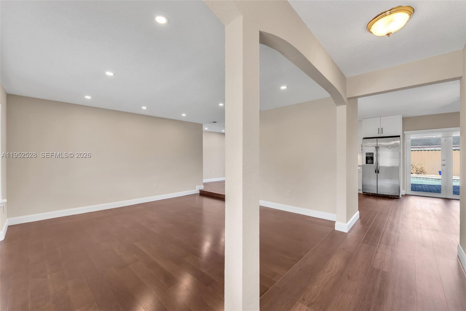 9567 Southwest 59th Terrace Miami, FL 33173 - Photo 5 of 36 an empty room with wooden floor and windows
