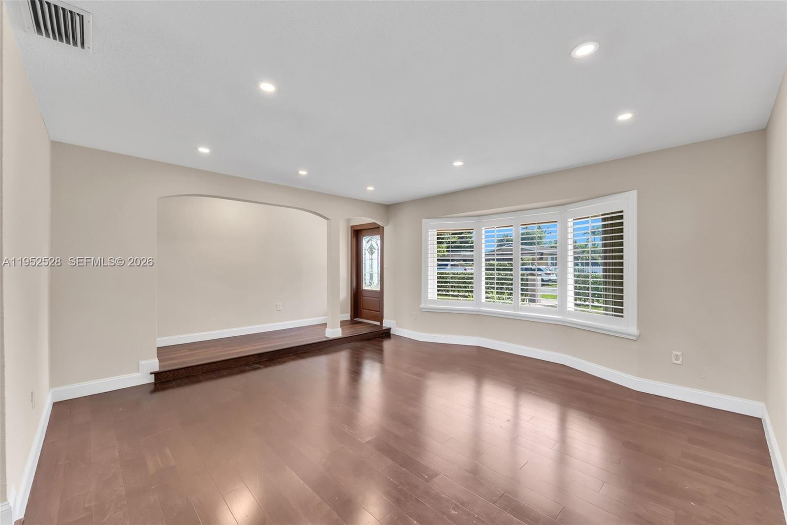 9567 Southwest 59th Terrace Miami, FL 33173 - Photo 6 of 36 a view of an empty room with wooden floor and a window