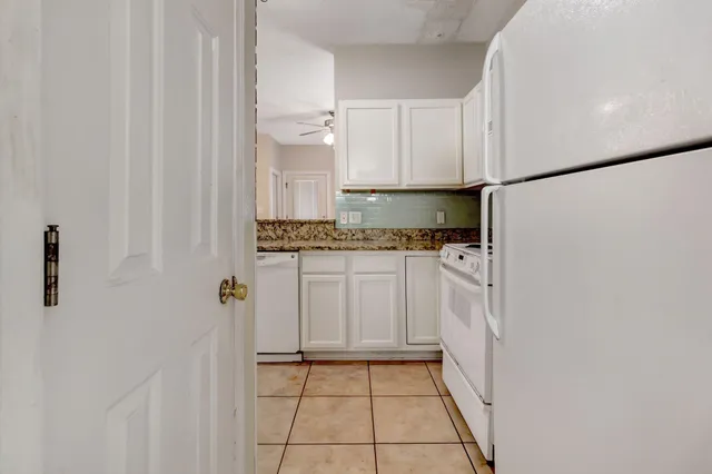 a kitchen with white cabinets and white appliances