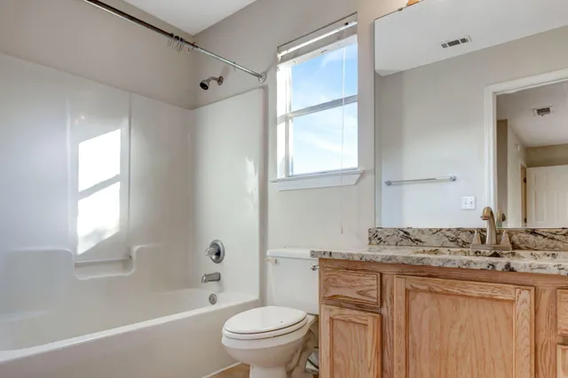a bathroom with a granite countertop sink toilet and shower