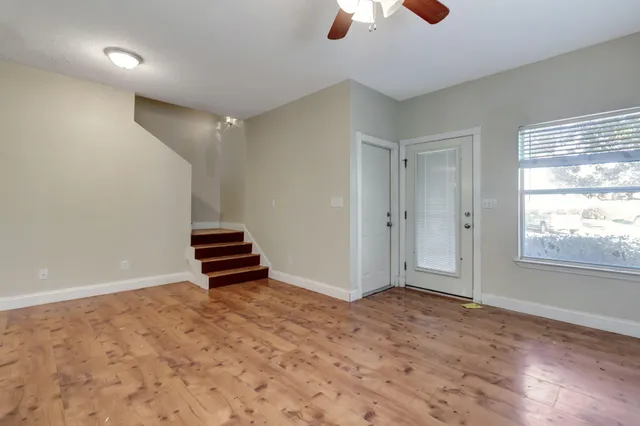 an empty room with windows and fan