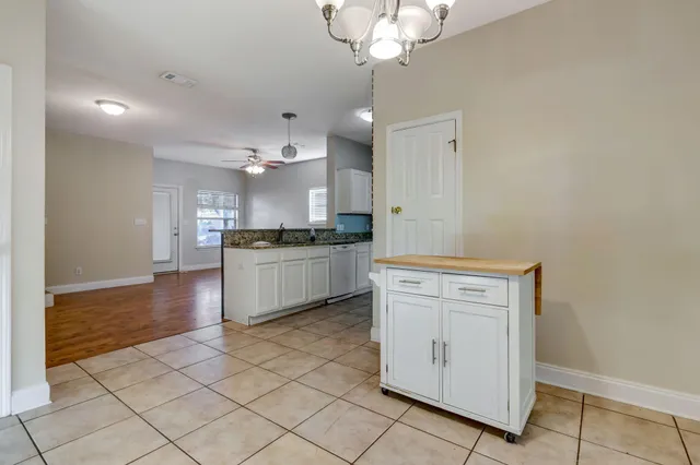 a kitchen with granite countertop white cabinets and white appliances