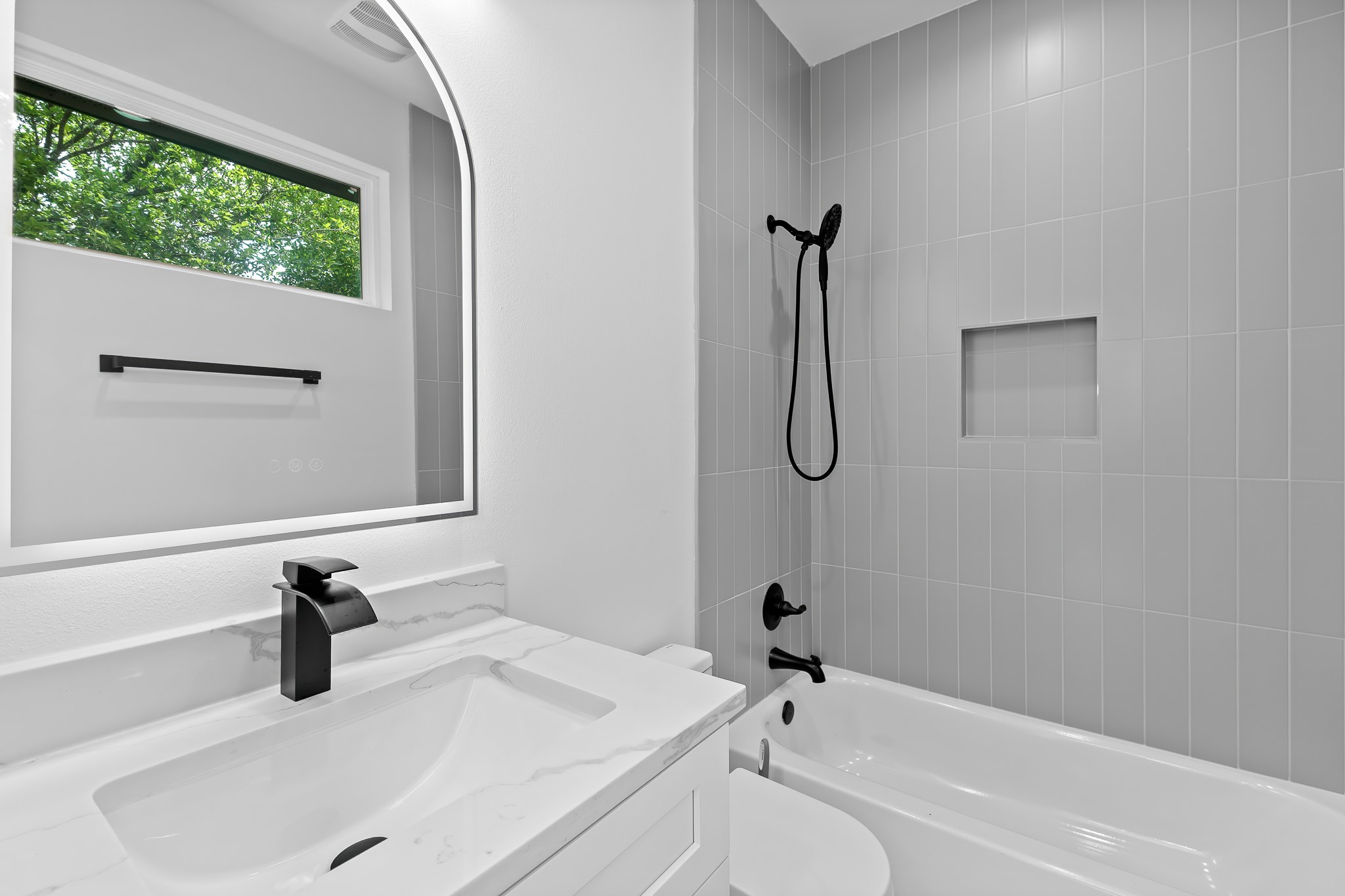 5305 Ledesma Road, Unit 4 Austin, TX 78721 - Photo 26 of 40 A refined bathroom featuring a contemporary vanity with a sleek faucet and an illuminated mirror.