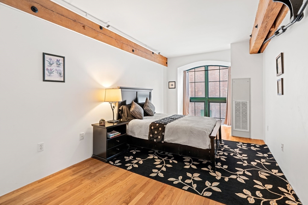 200 Market Street, Unit 103 Lowell, MA 01852 - Photo 13 of 22 a bedroom with bed and wooden floor