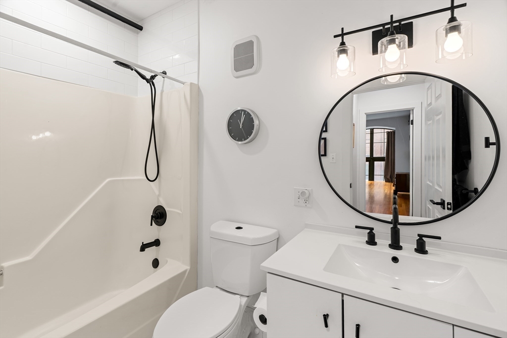 200 Market Street, Unit 103 Lowell, MA 01852 - Photo 17 of 22 a bathroom with a sink a toilet and a mirror