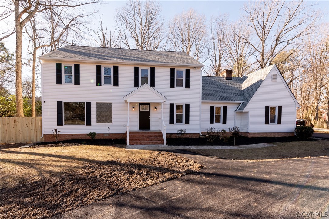 a view of a white house with a large tree in front of it