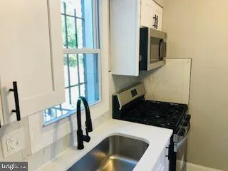 a kitchen with a sink a stove and a microwave