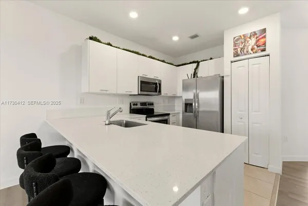 a kitchen with a refrigerator and a sink