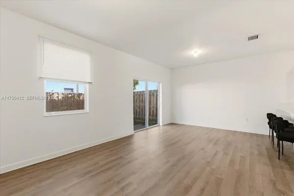 a view of an empty room with wooden floor