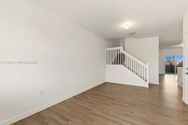 a view of a hallway with wooden floor