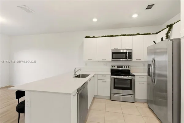 a kitchen with stainless steel appliances granite countertop a refrigerator sink and stove