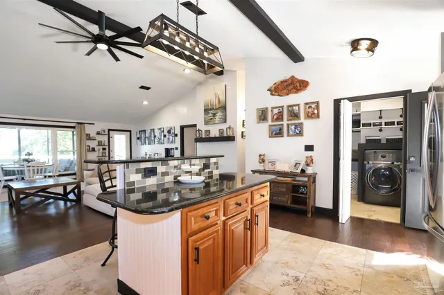 a kitchen with stainless steel appliances granite countertop a sink a stove and a refrigerator