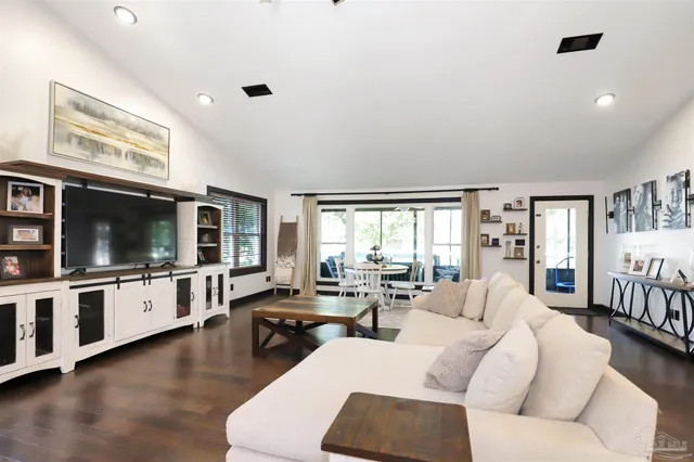a living room with furniture flat screen tv and large window